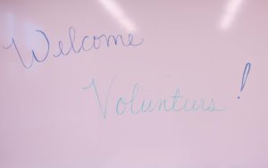 A whiteboard that says "Welcome, Volunteers"