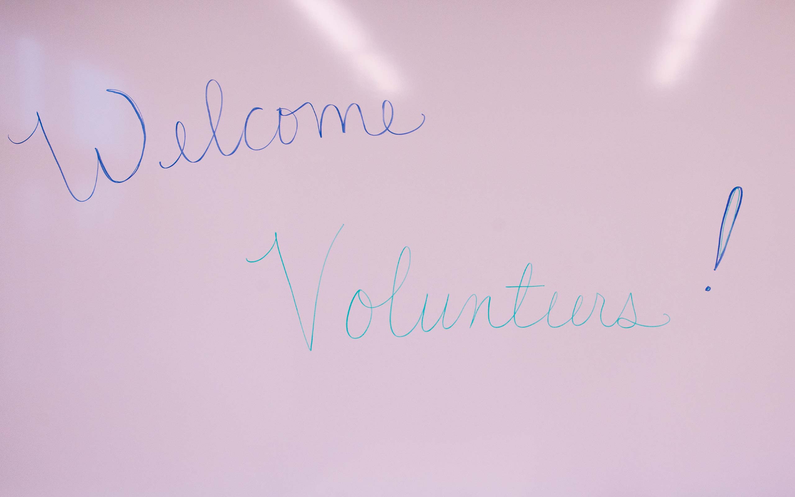 A whiteboard that says "Welcome, Volunteers"